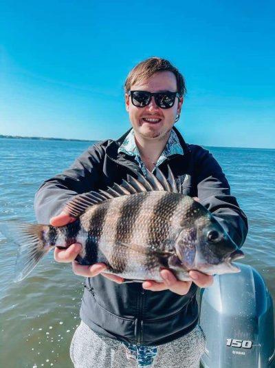 Angler holding an inshore catch during a private 30A fishing charter