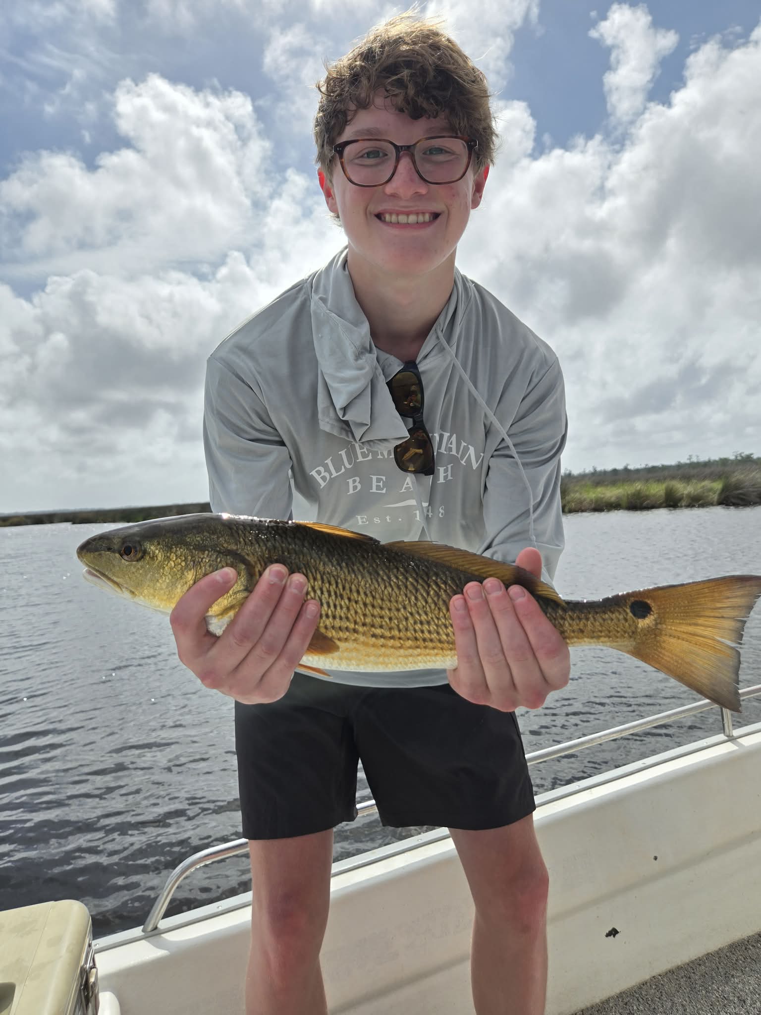 Family holding a redfish caught while fishing near 30A