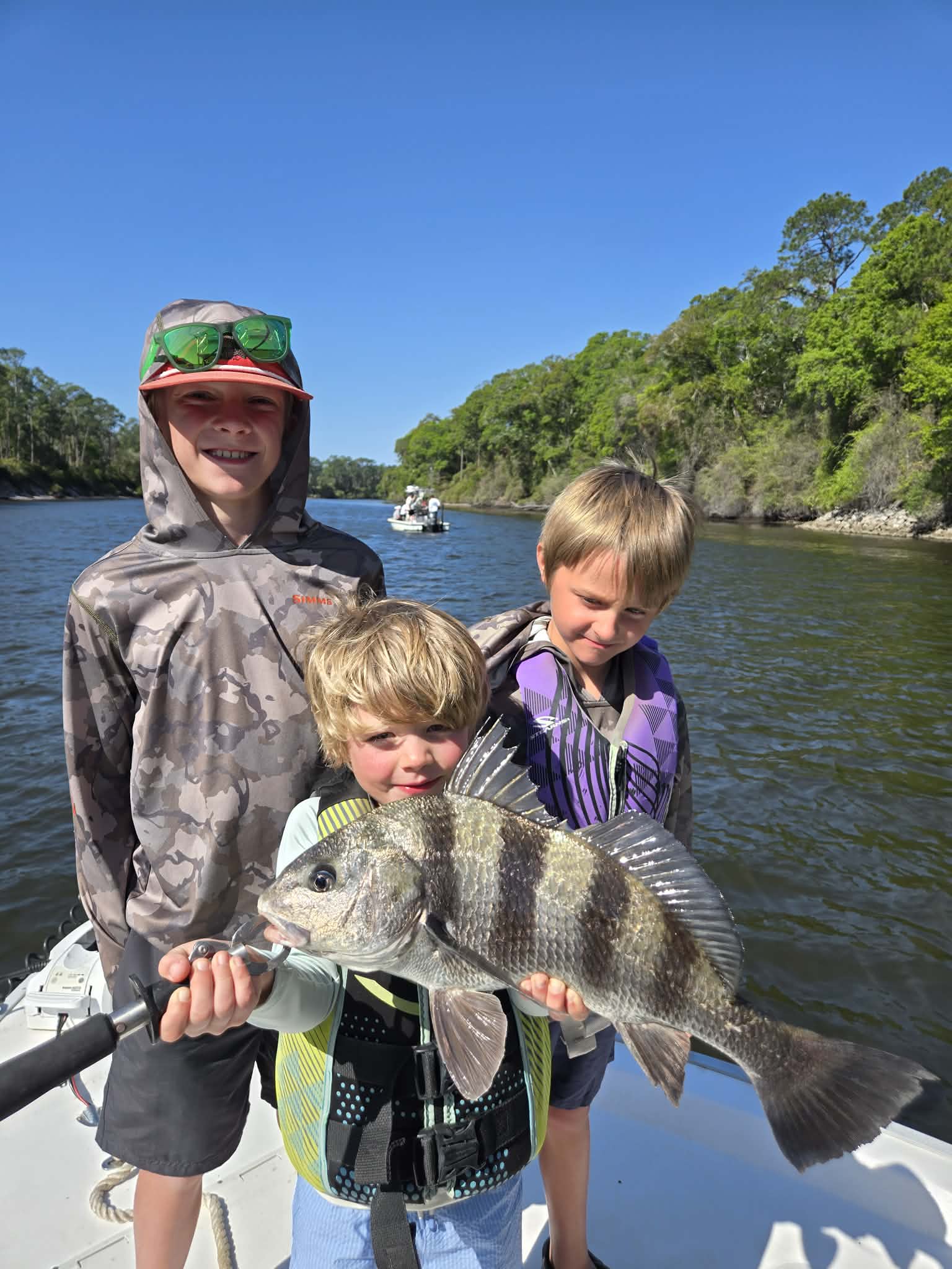 Guest holding a catch during a private 30A fishing charter